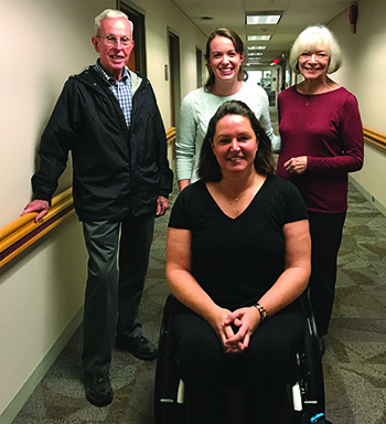 Sunnyview patient Kim Zilm, front, poses with Sunnyview advocates Hugh Murphy, Jenn Murphy, and Nan Murphy, whose philanthropy enabled the purchase of the Ekso robotic exoskeleton.