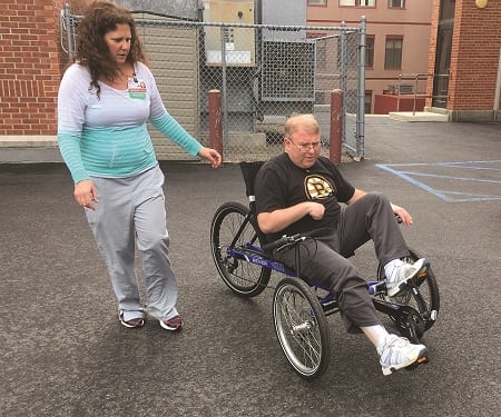 Sunnyview stroke patient, Ken Bernson, tries out the new trike with direction from recreational therapist Jennifer Battle, CTRS.
