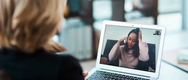 Shot of a young woman having a counselling session with a psychologist using a video conferencing tool